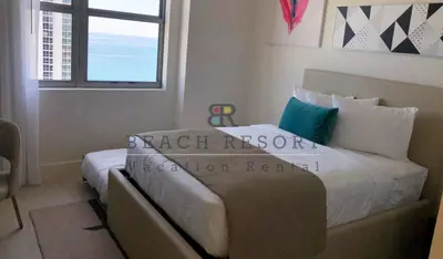 a bedroom with a bed with a couch next to a window at HYDE Beach House Apartments in Hollywood