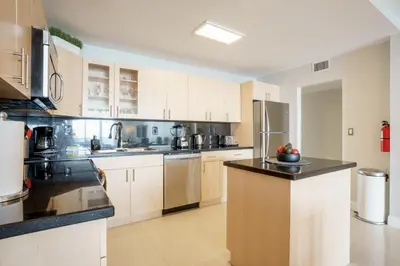 a large kitchen with white cabinets and stainless steel appliances at OCEAN RESERVE 15th Floor - Gorgeous Ocean View - STR00907 in Miami Beach