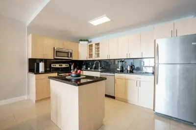 a large kitchen with a stainless steel refrigerator at OCEAN RESERVE 15th Floor - Gorgeous Ocean View - STR00907 in Miami Beach