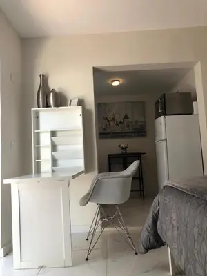 a bedroom with a white desk and a chair at Guayabita's House in Miami