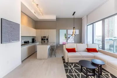a living room with a white couch and a kitchen at Amazing Apartments at H Beach House in Hollywood