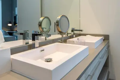 a bathroom with a sink and two mirrors at Amazing Apartments at H Beach House in Hollywood