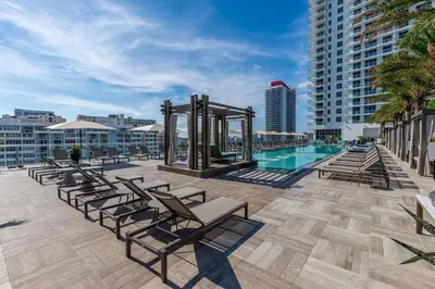 a patio with lounge chairs and a swimming pool at Amazing Apartments at H Beach House in Hollywood