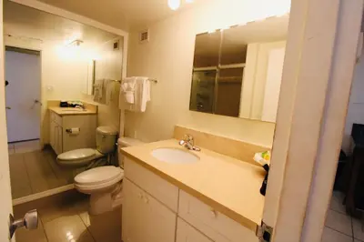 a bathroom with a sink and a toilet and a mirror at Alexander 1211 Beachfront Condo with Direct Beach Access, 2 Pools, Sauna, Gym in Miami Beach