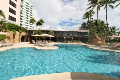 a large swimming pool in a resort with palm trees at Alexander 1211 Beachfront Condo with Direct Beach Access, 2 Pools, Sauna, Gym in Miami Beach