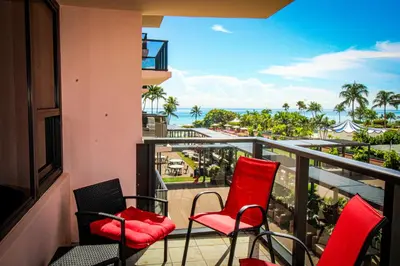 a balcony with red chairs and a view of the ocean at Alexander 511 Beachfront condo with 2 pools, direct beach access, sauna, tikki bar in Miami Beach