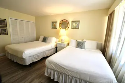 a bedroom with two beds and a mirror at Alexander 511 Beachfront condo with 2 pools, direct beach access, sauna, tikki bar in Miami Beach
