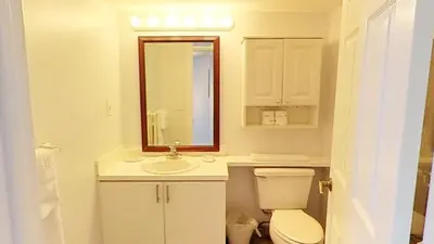 a bathroom with a toilet and a sink and a mirror at Castle M16 Oceanview Loft with Beach access, Pool, Tennis and Free Parking! in Miami Beach