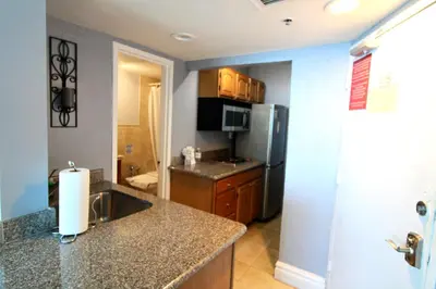 a kitchen with a sink and a refrigerator at Castle 828 Oceanfront view with balcony, pool, tennis, beach access and free parking! in Miami Beach