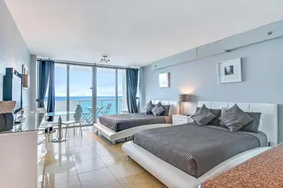 two beds in a room with a view of the ocean at Castle 828 Oceanfront view with balcony, pool, tennis, beach access and free parking! in Miami Beach