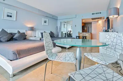 a bedroom with a bed and a glass table and chairs at Castle 828 Oceanfront view with balcony, pool, tennis, beach access and free parking! in Miami Beach