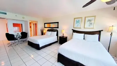 a hotel room with two beds and a desk at Castle 922 in Miami Beach