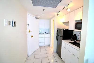 a kitchen with white cabinets and a black refrigerator at Castle 1033 in Miami Beach