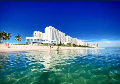 a group of people standing in the water at the beach at Castle L1 Double-Loft Condo with Beach Access, Pool, Tennis and Free Parking! in Miami Beach