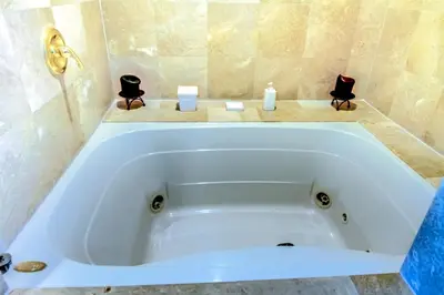 a white bath tub in a bathroom with two candles at Castle Ph3 in Miami Beach