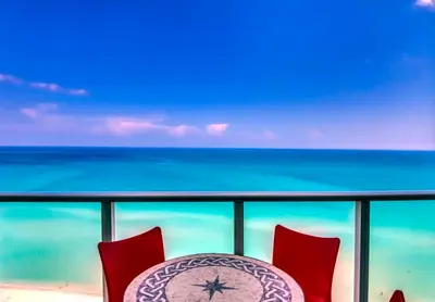 a table and chairs on a balcony with the ocean at Castle Ph3 in Miami Beach