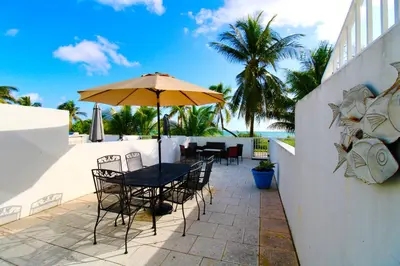 a patio with a table and chairs and an umbrella at Castle Th14 in Miami Beach