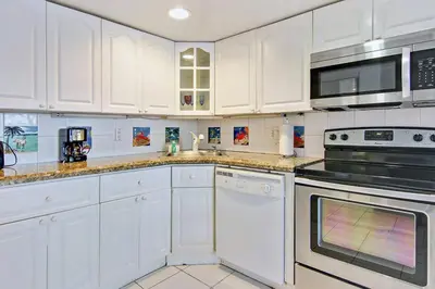 a kitchen with white cabinets and black appliances at Castle Th14 in Miami Beach
