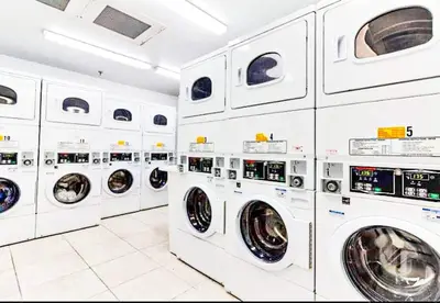 a bunch of white washing machines in a laundrette at Castle Th14 in Miami Beach