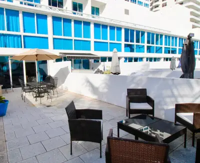 a patio with tables and chairs and a building at Castle Th14 in Miami Beach