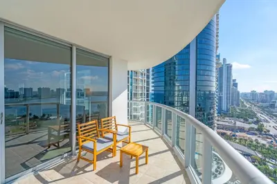 a balcony with two chairs and a view of a city at Steps to the Sand Beachfront Escape- 25th Floor Views in Miami Beach