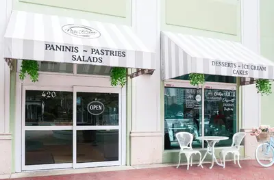 a store with tables and chairs in front of a building at Riverside Hotel in Fort Lauderdale