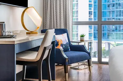 a hotel room with a desk and a mirror at Hyatt Centric Las Olas Fort Lauderdale in Fort Lauderdale