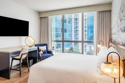 a hotel room with a bed and a desk and a large window at Hyatt Centric Las Olas Fort Lauderdale in Fort Lauderdale