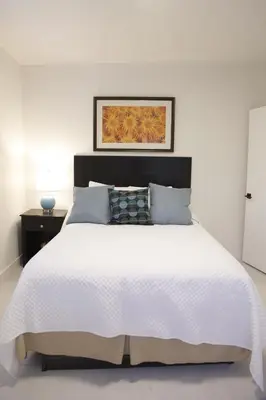 a bedroom with a white bed with a black headboard at Apt 1 Miami Designer Studio in the Upper East-Side in Miami