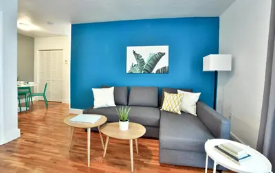 a living room with a couch and a blue wall at Broadwaysuites Downtown By RocketStay in Miami