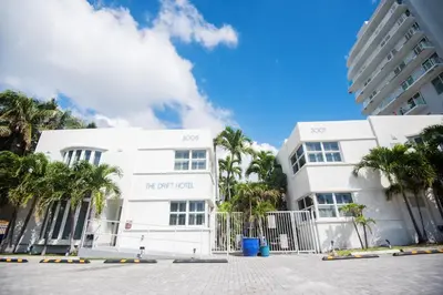 a white building with palm trees in front of it at The Drift Hotel in Fort Lauderdale