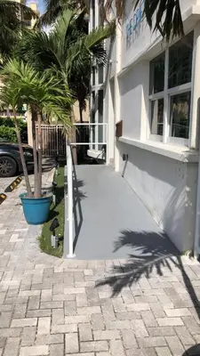a sidewalk in front of a building with palm trees at The Drift Hotel in Fort Lauderdale