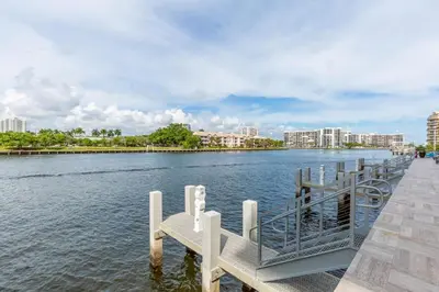 a dock with a bench next to the water at Ocean Breeze Retreat - Pool Gym Access Views in Hallandale Beach