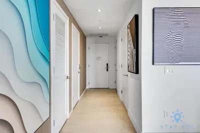 a hallway with white walls and a blue painting on the wall at Luxury 1Br-Front Intracoastal View Balcony - Pools in Hollywood