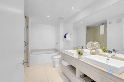 a white bathroom with two sinks and a toilet at Wrap Around Balcony - Paradise Beach - Amazing Pools in Hollywood