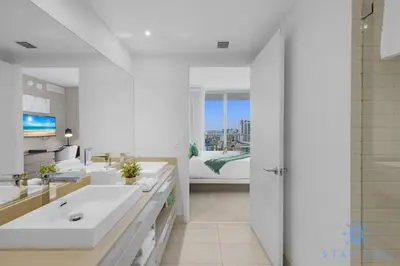 a white bathroom with two sinks and a bed at High-Floor with Stunning Views-Luxury Condo - Pools in Hollywood