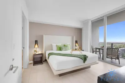 a bedroom with a large white bed and a balcony at High-Floor with Stunning Views-Luxury Condo - Pools in Hollywood