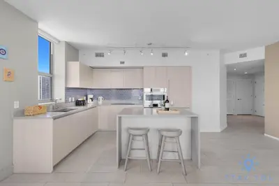 a kitchen with a counter and two bar stools at Luxury 2Br Front Ocean & Bay View, Amazing Pools in Hollywood