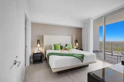 a bedroom with a large bed and a balcony at Luxury 2Br Front Ocean & Bay View, Amazing Pools in Hollywood