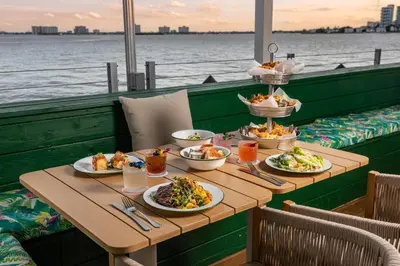 a table with plates of food on a cruise ship at Palm Tree Club Miami in Miami Beach