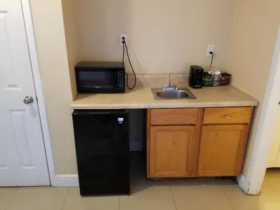a small kitchen with a sink and a microwave at Haven Hotel - Fort Lauderdale Airport & Cruise Port in Fort Lauderdale