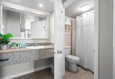 a bathroom with a toilet and a sink and a mirror at Hotolos Hollywood in Hollywood