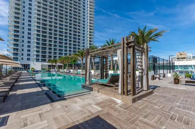 a pool with a gazebo next to a building at Espectacular Condo Esquina Beach House Hollywood Apartamento in Hollywood