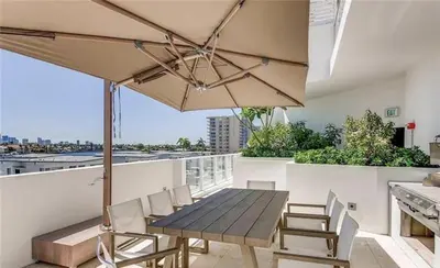 a table and chairs on a balcony with an umbrella at 914 Tiffany House condo in Fort Lauderdale