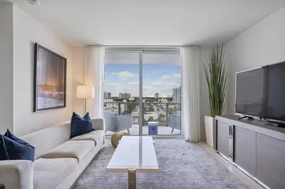 a living room with a couch and a flat screen tv at 914 Tiffany House condo in Fort Lauderdale