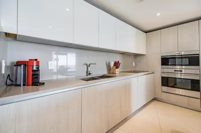 a kitchen with white cabinets and a sink at Amazing views on the 29th floor 2BR Beach Resort in Hallandale Beach