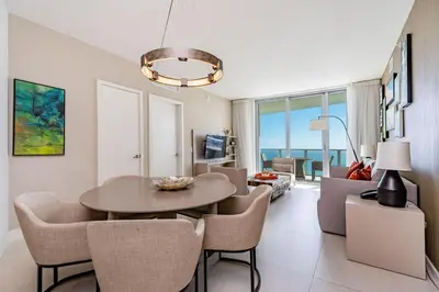 a living room with a table and chairs and a couch at Amazing views on the 29th floor 2BR Beach Resort in Hallandale Beach