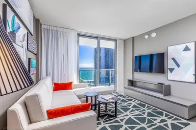 a living room with a couch and a tv at Hyde Beach House Hollywood Private Suites in Hollywood