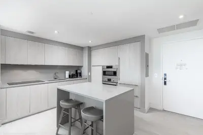 a kitchen with a white counter and stools in it at Hyde Beach House Hollywood Private Suites in Hollywood