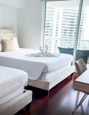 two beds in a hotel room with windows at Star Stay Miami Yellow Brickell in Miami